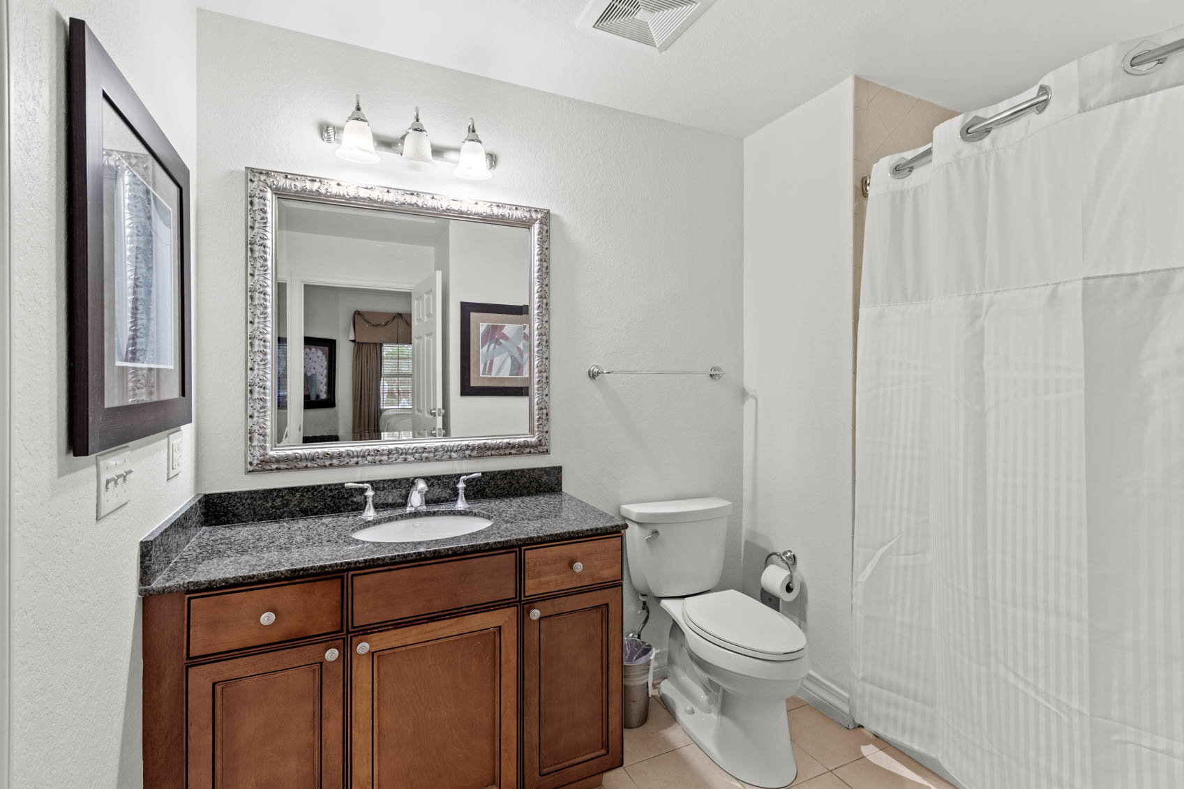bathroom with white shower curtain and dark cabinet